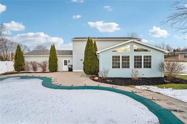 rear view of property featuring a gate, a patio area, and fence