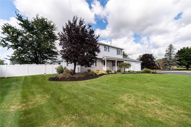 view of front of home with an attached garage, fence, a front lawn, and brick siding