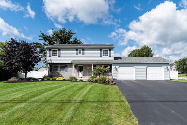 view of front of house with aphalt driveway, an attached garage, fence, a front lawn, and brick siding