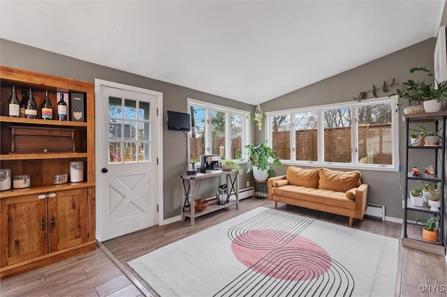 sitting room featuring light wood-style floors, a baseboard radiator, baseboards, and vaulted ceiling