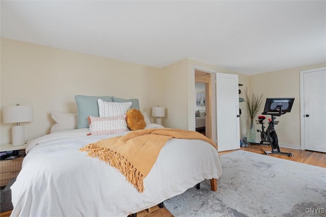 bedroom with baseboards and wood finished floors