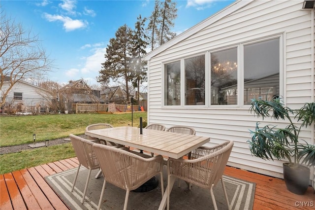 wooden deck with outdoor dining area, a yard, and fence