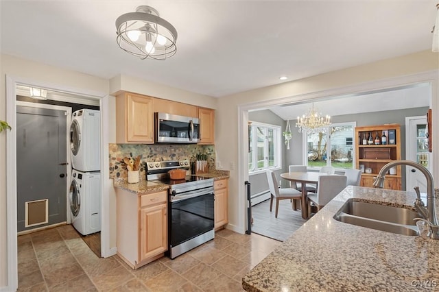 kitchen with decorative backsplash, stacked washer and clothes dryer, appliances with stainless steel finishes, light brown cabinets, and a sink