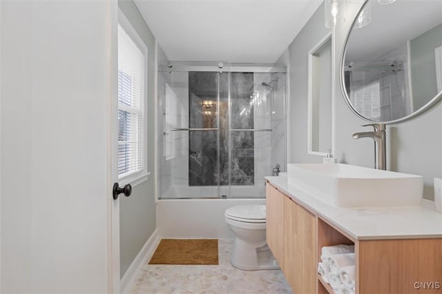 bathroom featuring baseboards, shower / bath combination with glass door, vanity, and toilet