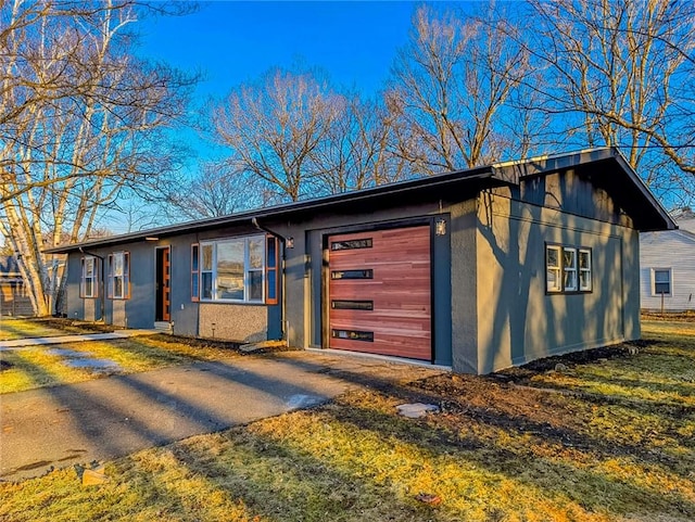 view of front of home featuring a garage, driveway, and stucco siding