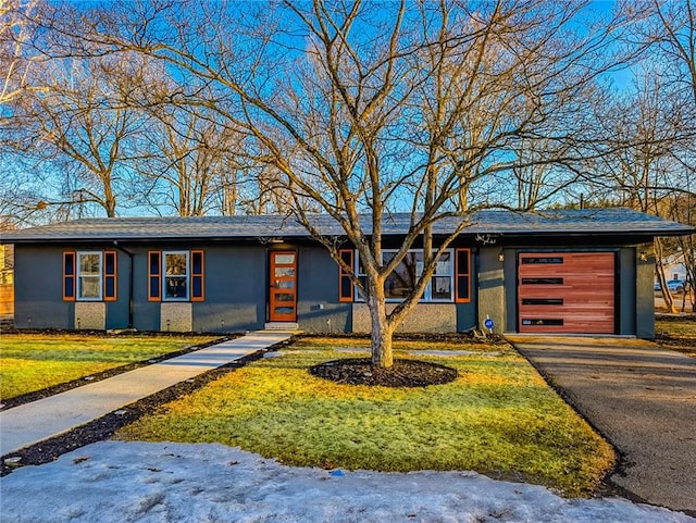 view of front of property with an attached garage, aphalt driveway, and stucco siding