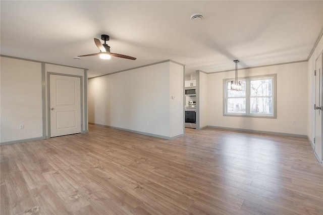 unfurnished living room featuring ceiling fan with notable chandelier, baseboards, light wood-style flooring, and crown molding