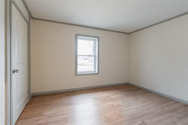 interior space with ornamental molding, light wood-style flooring, and baseboards