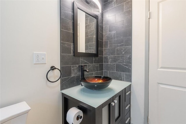 bathroom featuring toilet, tasteful backsplash, and vanity