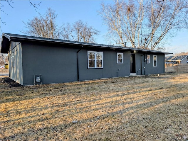 rear view of house featuring a yard and fence