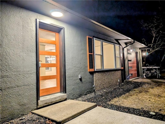 view of exterior entry with stucco siding