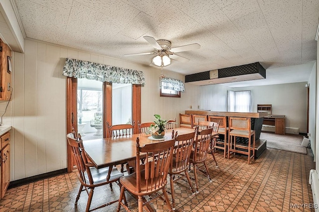 dining area with a healthy amount of sunlight, ceiling fan, baseboard heating, and tile patterned floors