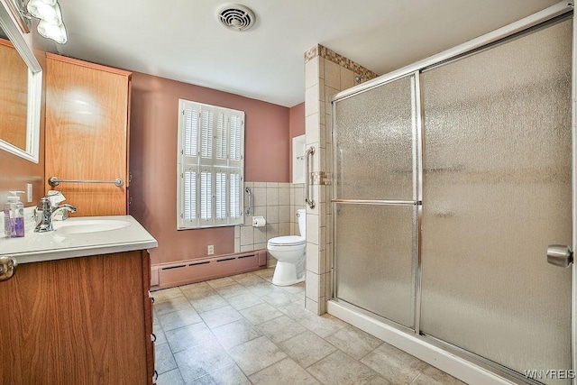 bathroom with toilet, visible vents, tile walls, baseboard heating, and a stall shower