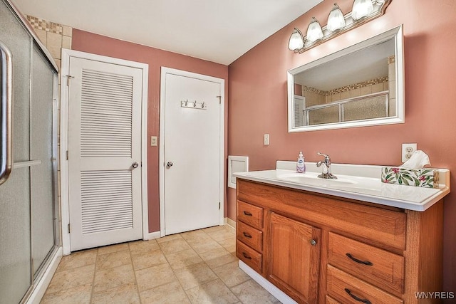 bathroom with a shower stall, baseboards, and vanity