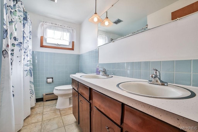 full bathroom with toilet, visible vents, a sink, and baseboard heating