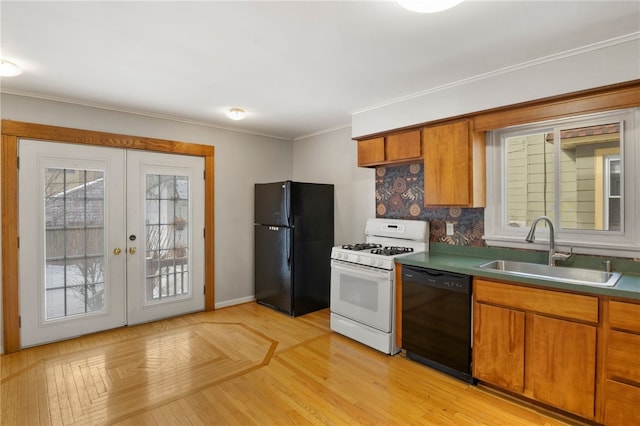 kitchen featuring a sink, ornamental molding, french doors, black appliances, and brown cabinetry