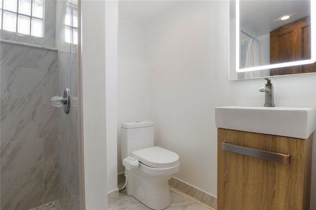 bathroom with toilet, marble finish floor, tiled shower, and vanity