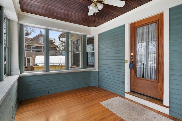 unfurnished sunroom with ceiling fan and wooden ceiling