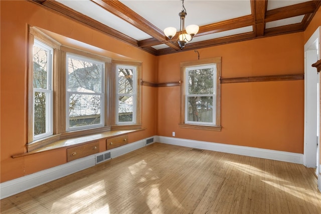 empty room featuring coffered ceiling, visible vents, and baseboards