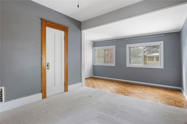 empty room featuring carpet flooring and baseboards