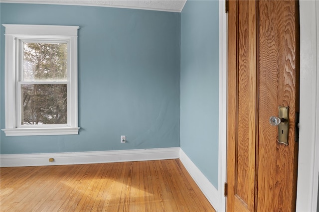 unfurnished room with baseboards and wood finished floors