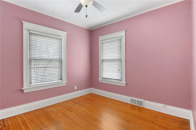 empty room with plenty of natural light, visible vents, baseboards, ceiling fan, and light wood-style flooring