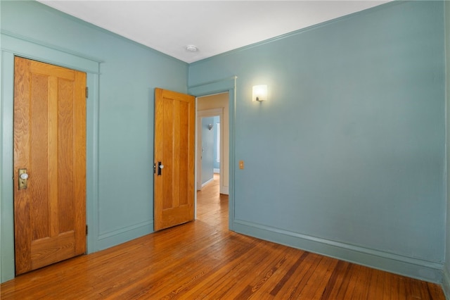 unfurnished bedroom featuring baseboards and wood finished floors