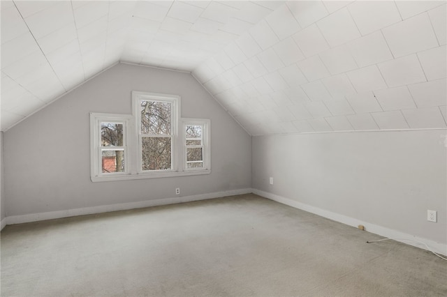 additional living space featuring carpet floors, lofted ceiling, and baseboards