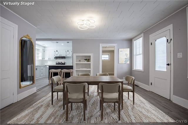 dining area with crown molding, baseboards, and wood finished floors