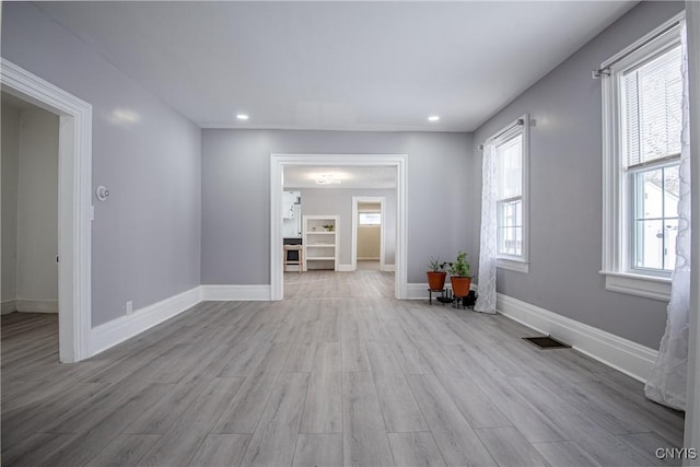 spare room featuring visible vents, baseboards, and wood finished floors