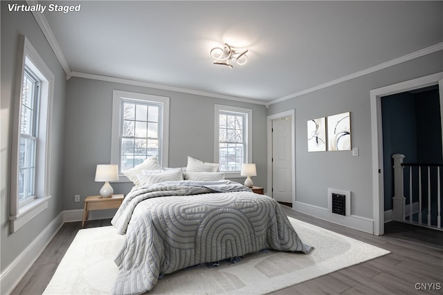 bedroom featuring ornamental molding, baseboards, and wood finished floors