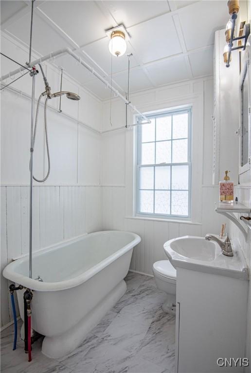 bathroom featuring a shower, marble finish floor, toilet, vanity, and a freestanding tub