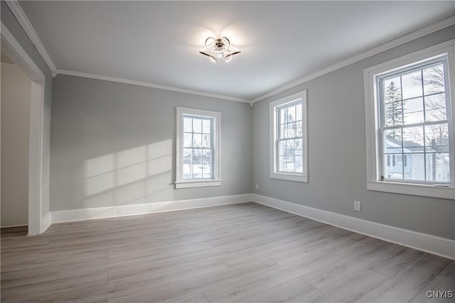 unfurnished room with baseboards, wood finished floors, and crown molding