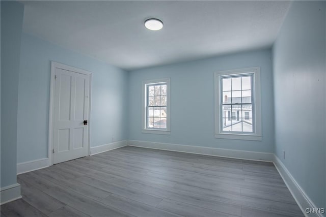 unfurnished room with baseboards and dark wood-type flooring