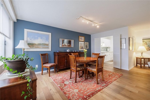 dining room featuring light wood-type flooring and baseboards