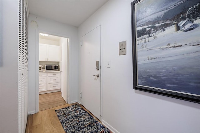 doorway to outside featuring light wood-style floors and baseboards