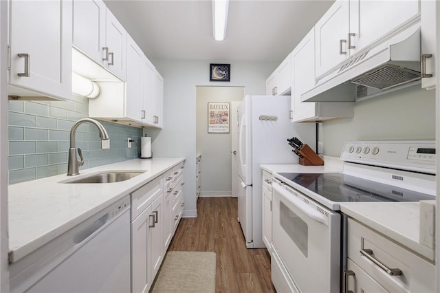 kitchen featuring decorative backsplash, white cabinets, a sink, white appliances, and under cabinet range hood