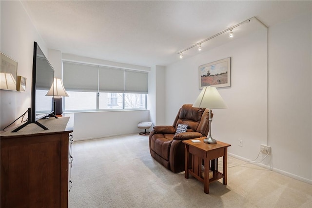 sitting room with light carpet, baseboards, and track lighting