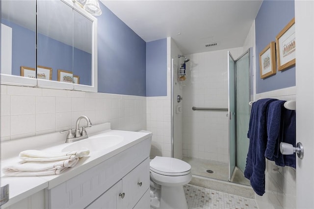 bathroom featuring toilet, a stall shower, visible vents, and tile walls