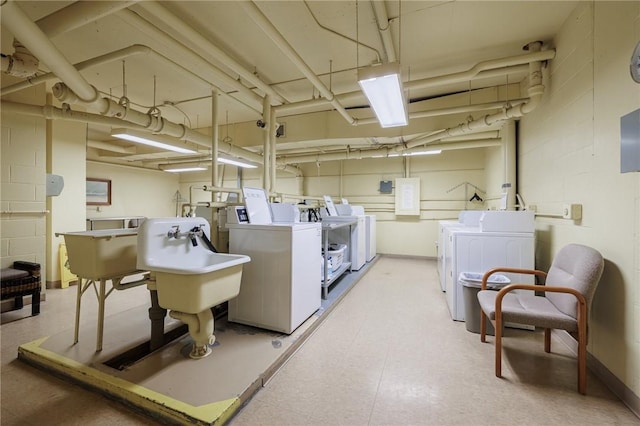 common laundry area with baseboards, washer and clothes dryer, and light floors