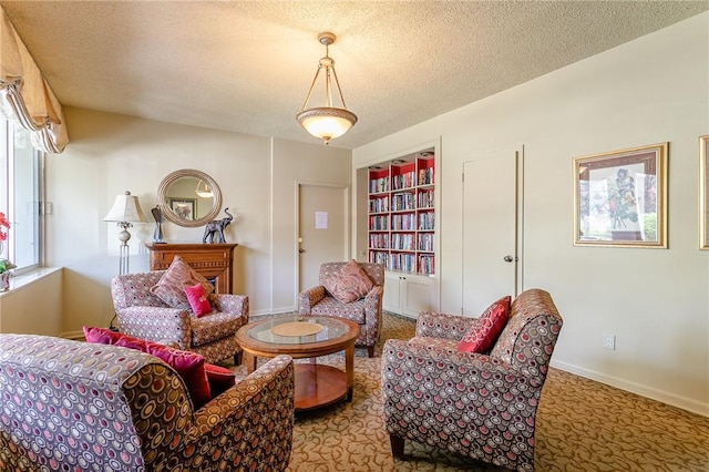 living area with baseboards, built in features, a textured ceiling, and carpet flooring