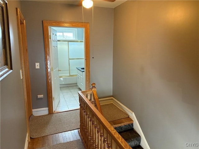 corridor with light wood-style floors and baseboards