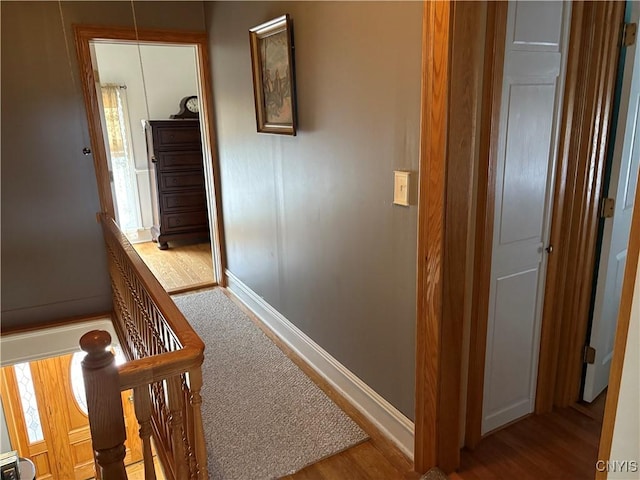 hallway featuring wood finished floors and baseboards