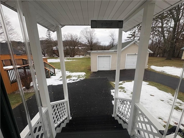 deck with a garage, a yard, and an outdoor structure