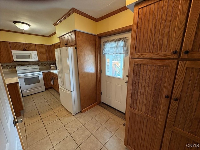 kitchen with white appliances, light tile patterned floors, light countertops, and crown molding