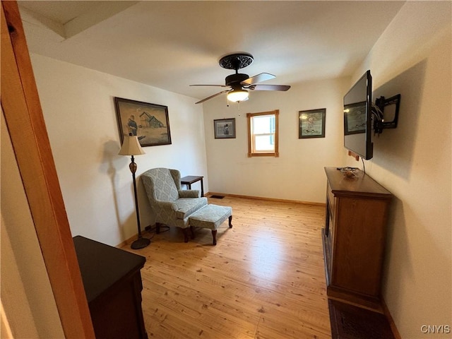 sitting room with baseboards, ceiling fan, and light wood finished floors