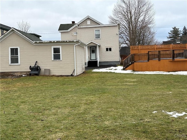 back of house with a deck and a lawn