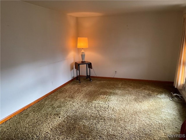 unfurnished room featuring carpet flooring and baseboards