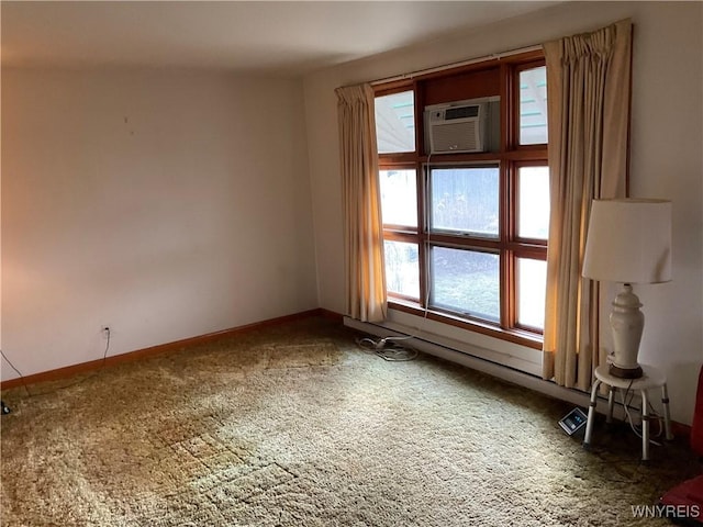 unfurnished room with a wall mounted air conditioner, carpet flooring, and baseboards