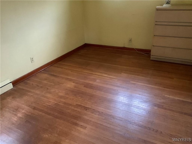 unfurnished room featuring baseboards and wood finished floors